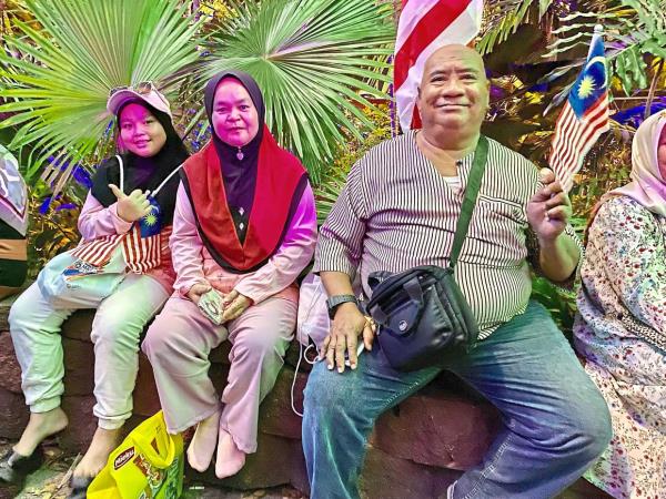 Hamdan and his family are all smiles after finally making it to the Malaysia Day celebrations at Padang Merdeka in Kota Kinabalu.